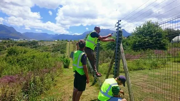 The team installing a fence on a rural property