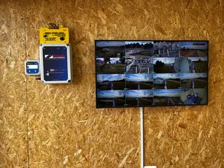CCTV monitor showing multiple camera feeds beside a fence energiser