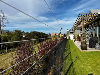 Electric fence wires along a garden boundary