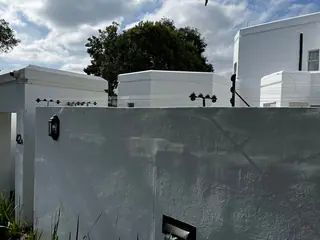 Security lighting on a white boundary wall