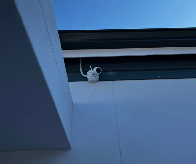 Compact camera mounted under the eaves of a house
